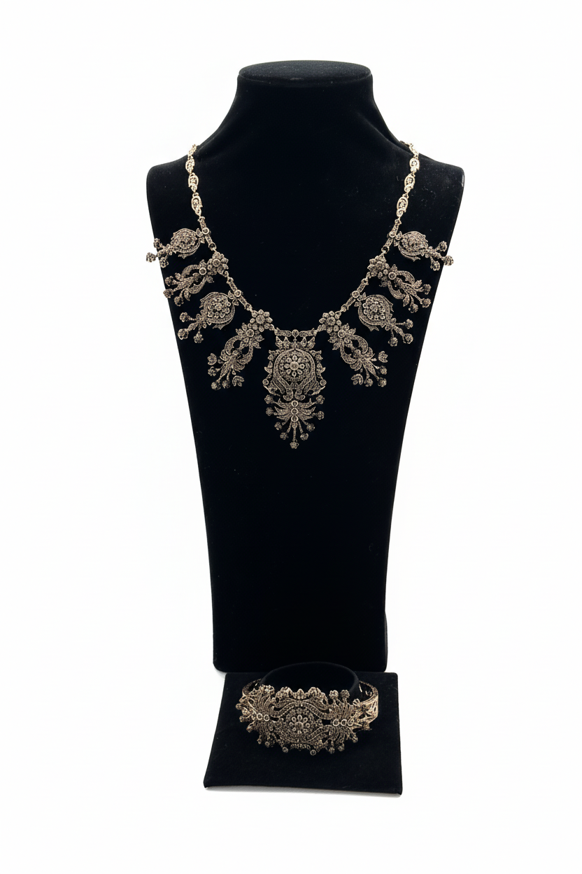 Beyaz arka plan üzerinde antik gümüş filigran çiçek motifli kolye ve bileklik seti