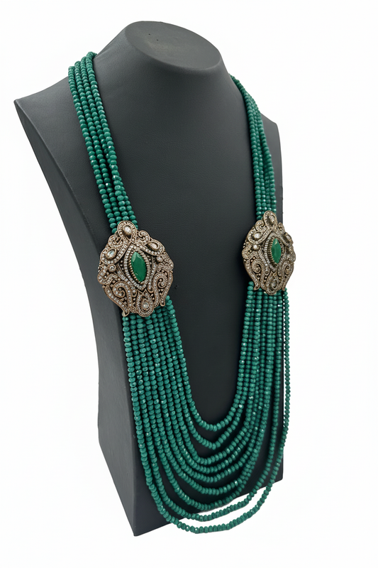 Beyaz arka plan üzerinde çok sıralı yeşil boncuk kolye ve bronz toka