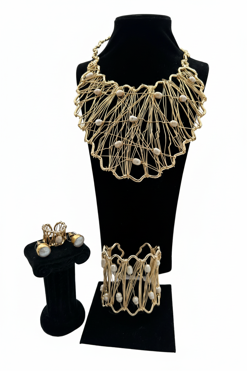 Beyaz arka plan üzerinde altın kaplamalı pirinç tel örgü beyaz boncuk aksamlı kolye bilezik ve yüzük seti