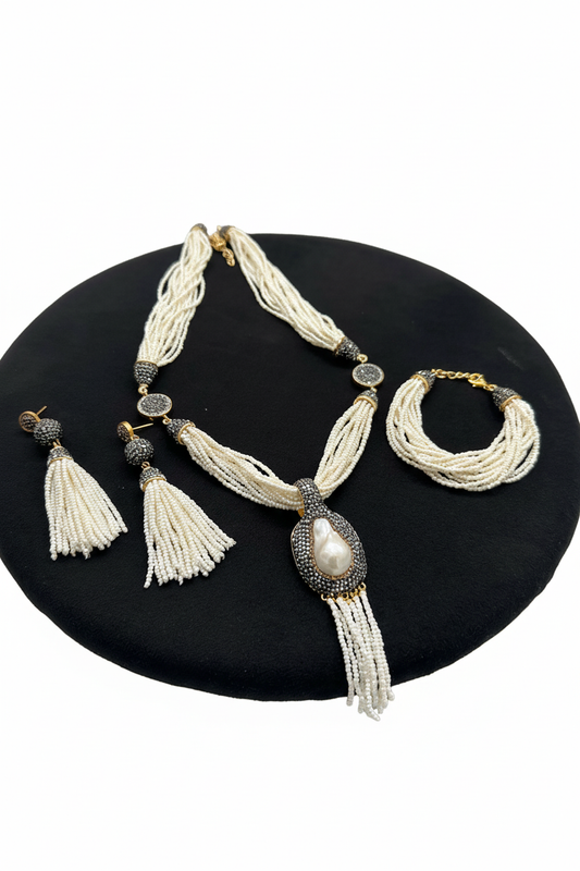 Beyaz arka plan üzerinde beyaz boncuk püsküllü kolye küpe ve bilezik seti