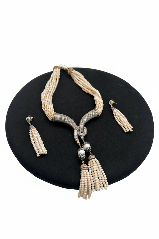 Beyaz arka plan üzerinde krem boncuk markazit tokalı püsküllü kolye ve küpe seti
