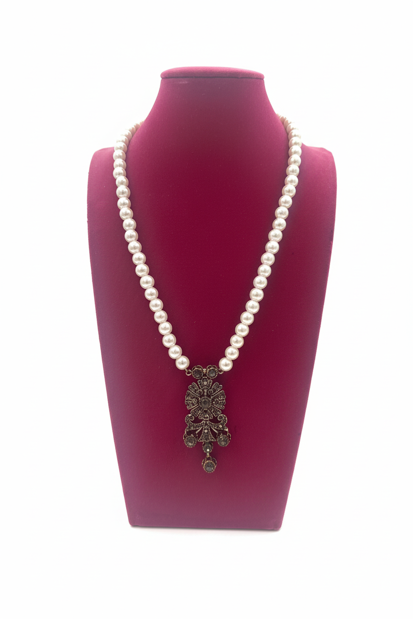 Beyaz arka plan üzerinde inci kolye ve antik gümüş pandantif