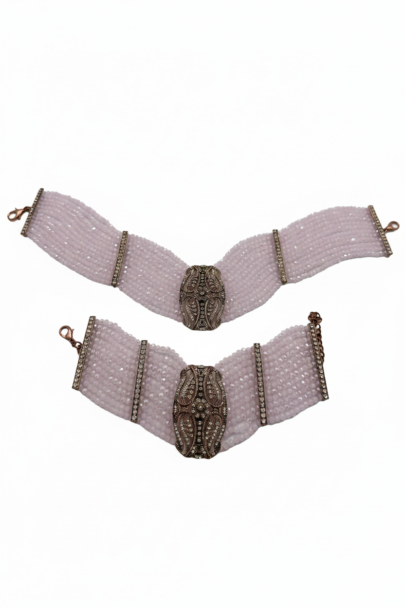 Beyaz arka plan üzerinde pembe kristal boncuklu bronz oval motifli bilezik seti