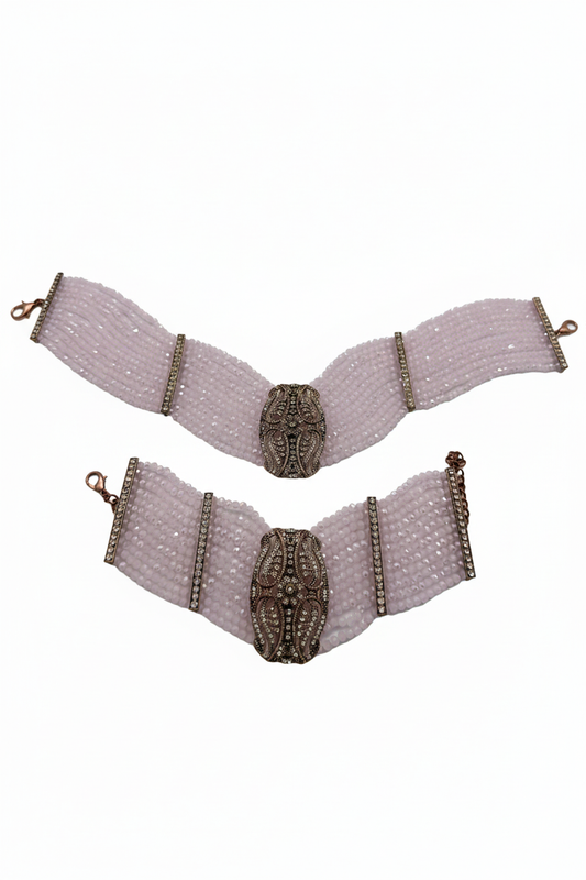 Beyaz arka plan üzerinde pembe kristal boncuklu bronz oval motifli bilezik seti