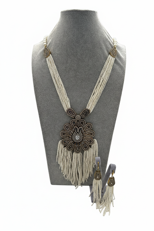 Beyaz arka plan üzerinde beyaz boncuk bronz paisley sarkıtlı püsküllü kolye ve küpe seti