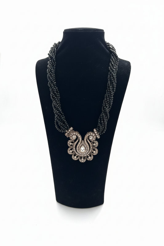 Beyaz arka plan üzerinde siyah çok katmanlı boncuk kolye, antik bronz taş işlemeli şemse motifli orta süs