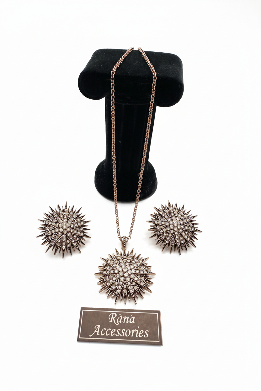Beyaz arka plan üzerinde yıldız motifli bronz kolye ve küpe seti