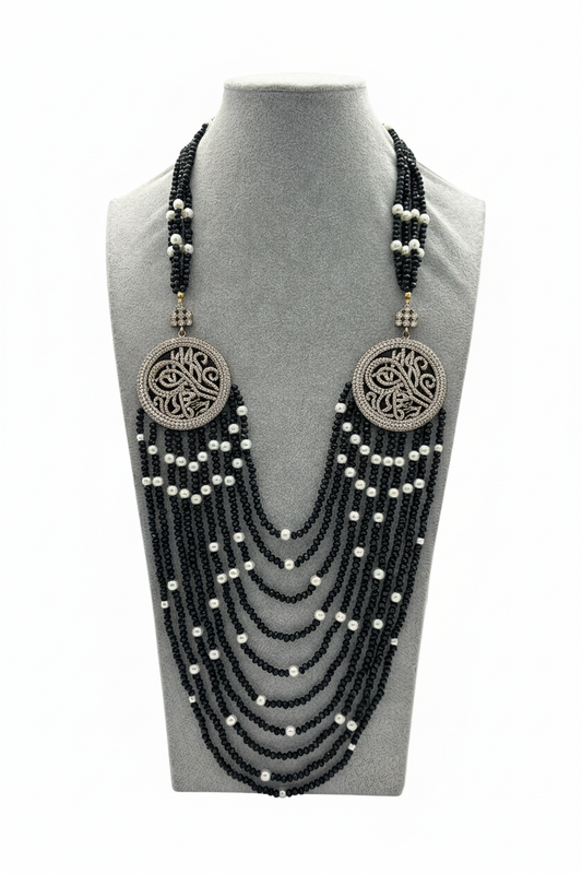 Beyaz arka plan üzerinde siyah boncuk beyaz boncuk aksamlı Besmele tuğralı madalyon uzun kolye