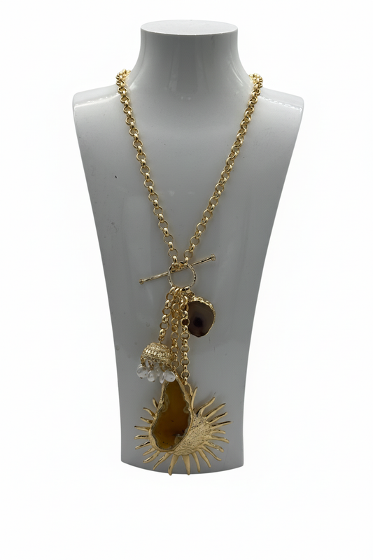 Beyaz arka plan üzerinde gold rengi zincir kolye, güneş motifli akik taş ve çan sarkıtı aksesuarlı