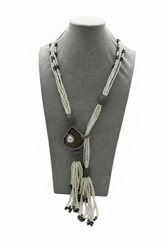 Beyaz arka plan üzerinde beyaz boncuk siyah boncuk aksamlı markazit damla sarkıtlı püsküllü uzun kolye
