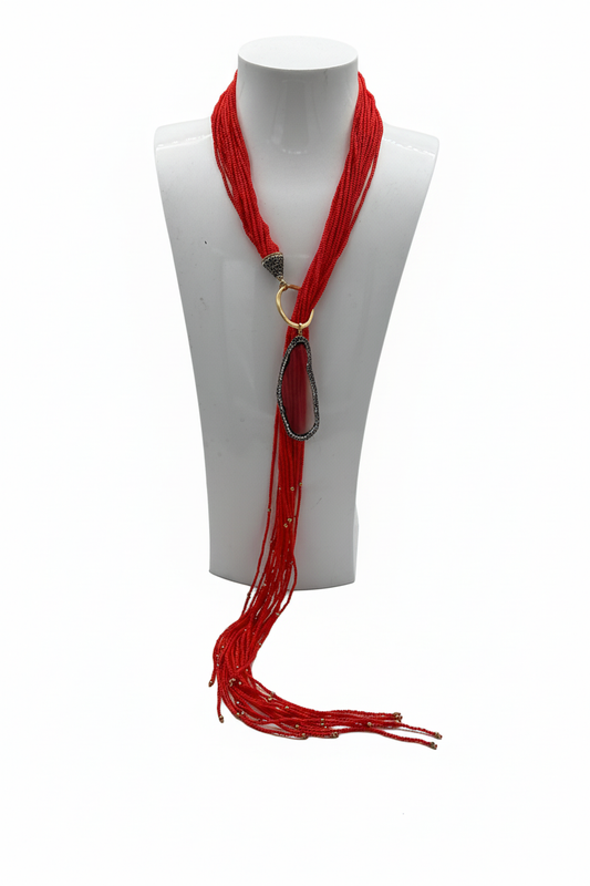 Beyaz arka plan üzerinde kırmızı çok katmanlı boncuk kolye, oval akik taş ve uzun sarkıtı boncuk uçlar